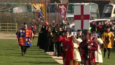 Historians in tudor costumes carrying flags