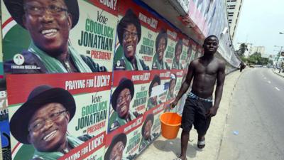 A man walk past campaign posters of Nigerian President Goodluck Jonathan and candidate of the ruling People's Democratic Party in Lagos on 21 March 2015