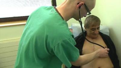 Cardiologist checking Huseyin Ulucan's heart with a stethoscope