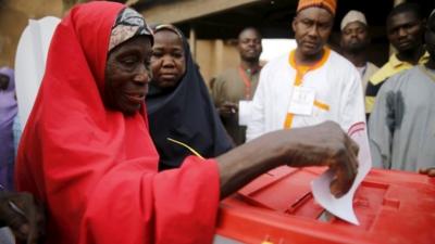 A woman casts her vote at a polling unit in Daura, northwest Nigeria