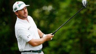 McDowell watches his tee shot at the second hole on Friday