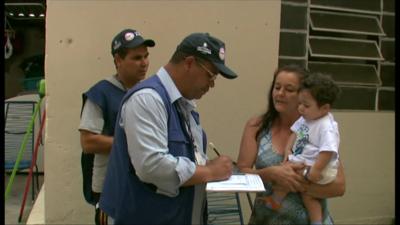 A dengue inspector speaks with a local resident