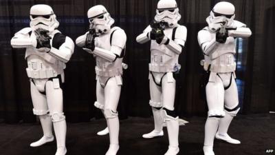 Fans dressed in costume pose on the opening day of the 25th Star Wars Convention in California