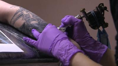 arm being tattooed