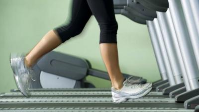 Woman running on treadmill in gym