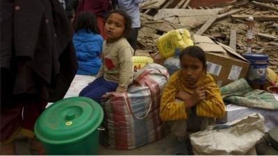 Children sit in rubble after earthquake