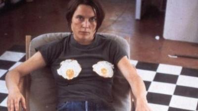 Sarah Lucas sitting with two fried eggs on her chest