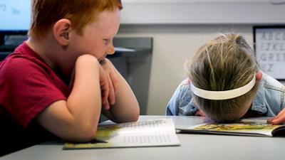 Boy and girl with head on desk