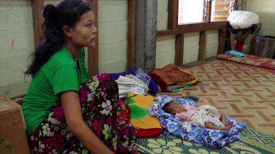 Lady sits next her baby