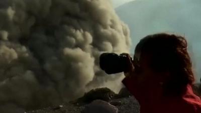 People pointing cameras at cloud of ash