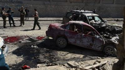 Afghan and foreign security forces inspect the site of the attack