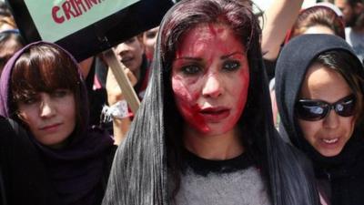 Afghan protestors, one with fake blood smeared on her face, demand justice for woman beaten to death by a mob, in Kabul, Afghanistan, 27 April 2015