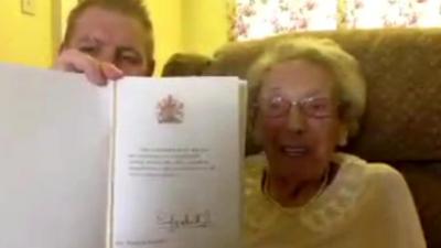 Darren Pinder and Winnie Blagden with a birthday card from the Queen