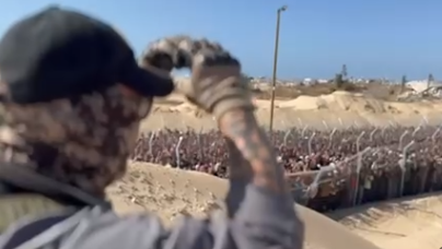 A contractor makes a heart shape with his hands to the crowd. He is wearing a mask and baseball cap.