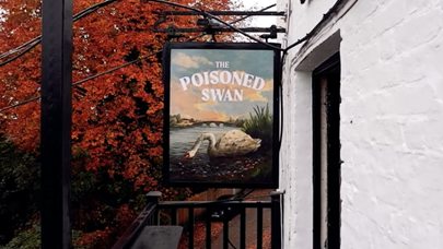 View from a balcony showing a swinging painted sign saying 'The Poisoned Swan'. the painting features a dirt-covered swan bending down to the water to drink, surrounded by cigarette butts