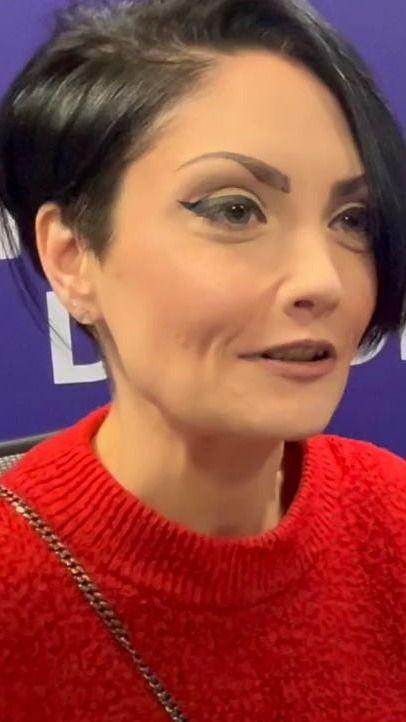 Gillian Nair looking to the right. She has short black hair and is wearing a red jumper.