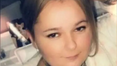 Deseree Fitzpatrick, with light brown hair and wearing silver earrings, smiles while being photographed.