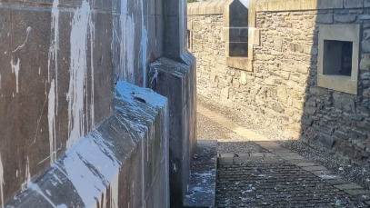 a paint covered walkers plinth in derry with the city's walls in the background