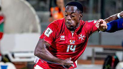 Malta's Basil Tuma, in red shirt, holds off Memphis Depay of the Netherlands, in all blue