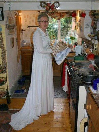 Sue in her wedding dress cooking Christmas dinner