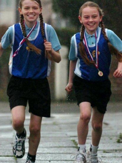 Zoe runs with her sister Beth, aged ten, after they had won their races at the Primary Cross Country championships.