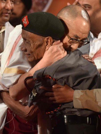 In this photograph taken on 2 April 2017, Tibetan spiritual leader the Dalai Lama (L) shakes hands with retired Assam Rifles personnel Naren Chandra Das