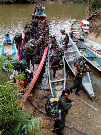 A handout photo provided by the Farc rebels shows them disembarking from a canoe