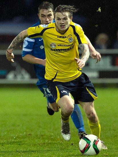 Paul McElroy of Dungannon Swifts goes on the offensive with Ballinamallard United defender Emmett Friars in pursuit