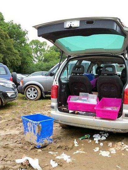 Car boot open, rubbish on ground