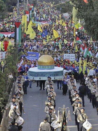 Lebanese demonstrators march with a model of the Dome of the Rock, along with their national flags and Palestinian flags as well as the yellow banners of the Shia movement Hezbollah during a protest in the capital, Beirut, on 11 December 2017