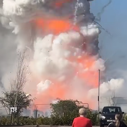 A grey plume of smoke with orange flames 