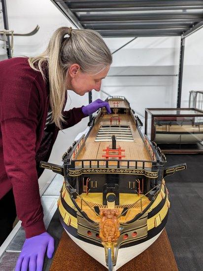 The model is inspected by Principal Curator Victoria Ingles before going on display