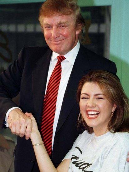 Miss Universe 1996, Alicia Machado of Venezuela, (R) is greeted by businessman Donald Trump during a staged workout at a gym in New York in a January 28, 1997