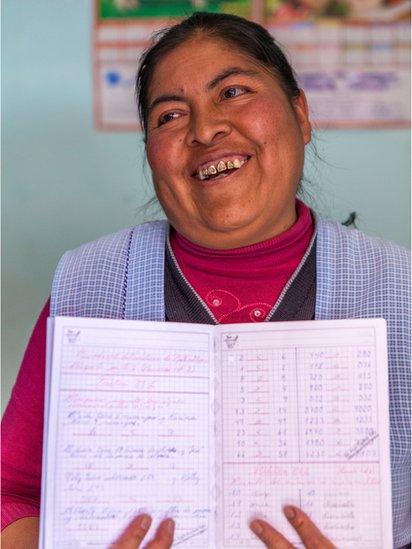 A student proudly holds up her notebook