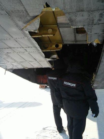 Police examine broken hatch on cargo plane