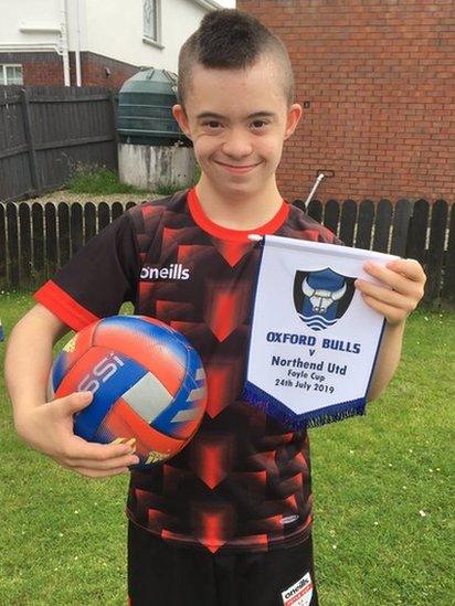 Adam Morrison from the Oxford Bulls proudly displays his side's pennant from a Foyle Cup match