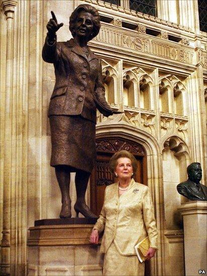 Y Farwnes Thatcher o flaen y cerflun efydd iddi ym Mhalas Westminster