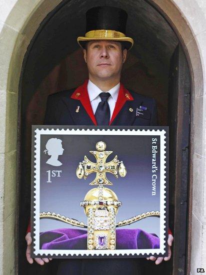 A warder outside the Tower of London holds a new Royal Mail stamp of the crown jewels.