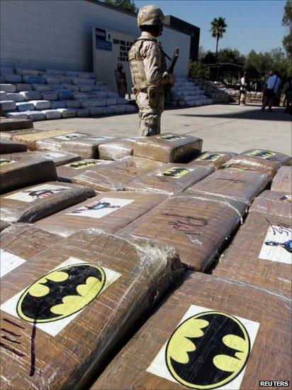 A soldier stands next to packages containing marijuana and marked with Batman and Captain America stickers in Tijuana, 13 October 2011