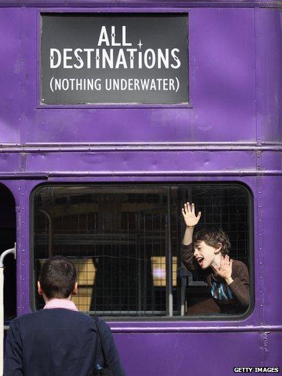 Two visitors play on one of the buses at the Harry Potter studio tour.