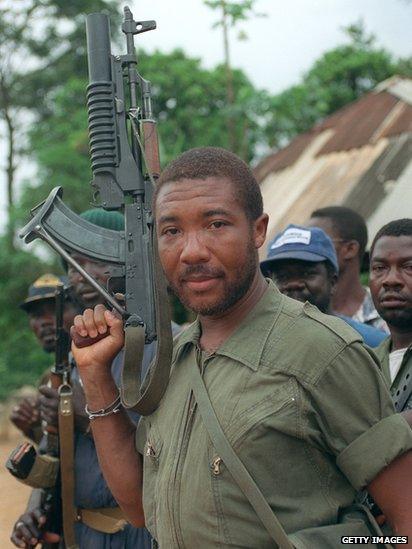 Charles Taylor holds his Soviet-made AK-47 assault rifle in Buchanan 29 May 1990 as he continues his march on the capital Monrovia to oust President Samuel Doe after a five-month-old insurgency.