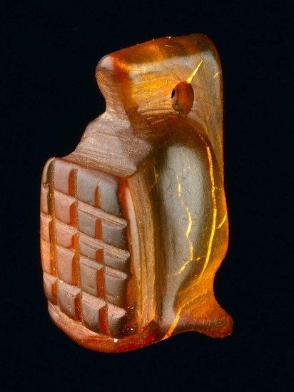 An amber amulet in the shape of a gladiator's helmet