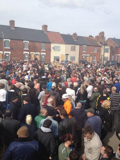 Crowds gather around bonfire