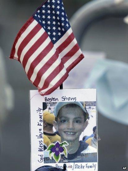 A photograph of bombing victim Martin Richard is attached to a barricade in Boston at a makeshift memorial