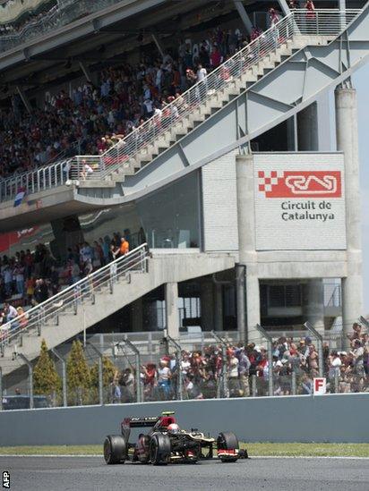 Romain Grosjean drives his Lotus in front of the packed grandstand