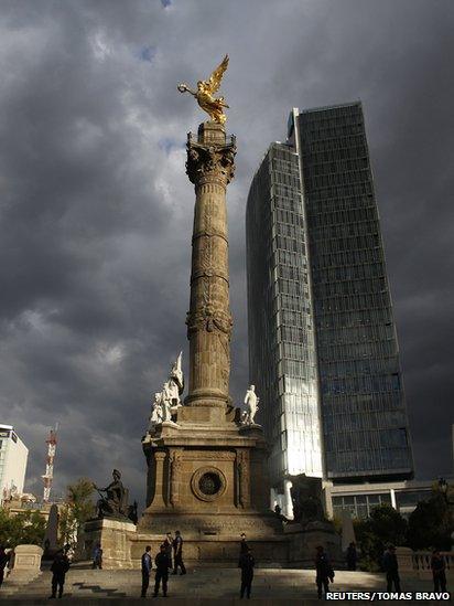 Police officers stand guard at the Angel of Independence monument before a protest against the privatisation of the state oil monopoly Pemex in Mexico City, 1 July