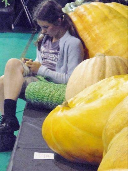 Girl sitting by big pumpkin