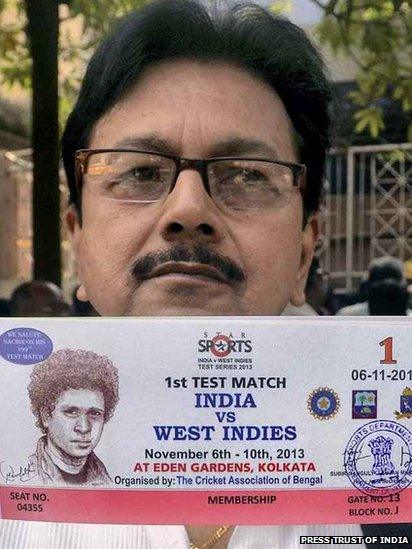 A man showing a ticket, bearing the picture of Sachin Tendulkar for India's Test match against West Indies in Calcutta