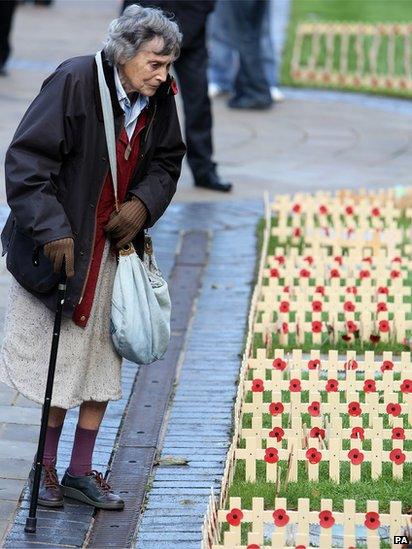 A woman looks at tributes during the Armistice Day service, at the cenotaph at City Hall, Belfast