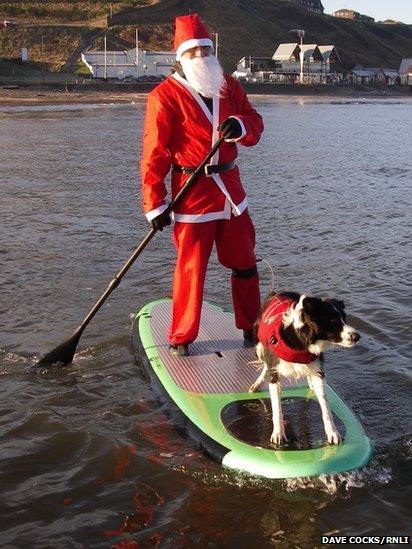 Man surfing with dog